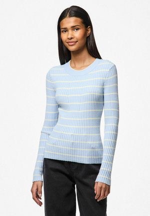 Ljust blå ribbad tröja med gula ränder, långa ärmar och rund halsringning, i kombination med mörka jeans. Texturen är mjuk och åtsittande.