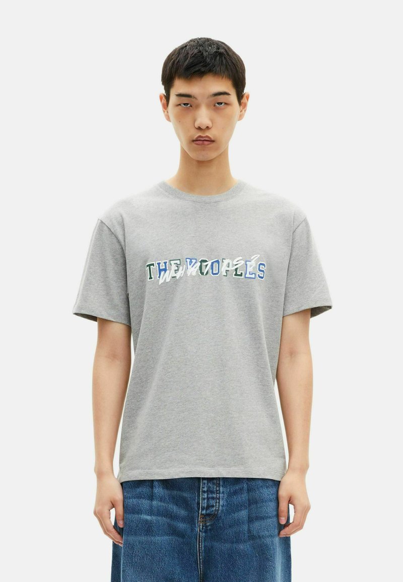 Gray cotton t-shirt with short sleeves, featuring multicolored text "THE WOLVES" in a wavy, distorted style across the front.