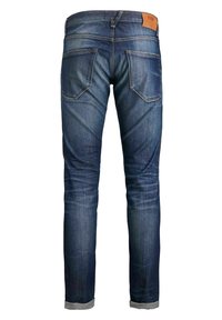Vaqueros de denim azul oscuro con corte recto, cinco bolsillos, parche de cuero en la cinturilla y dobladillos con vuelta. Presentan un desgaste notable.
