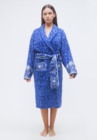 Μπλε ρόμπα από πετσέτα με υφή που σχηματίζει το λογότυπο "VERSACE", μακριά μανίκια και ζώνη με floral μοτίβο καθώς και τσέπη.
