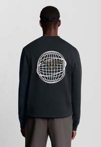 Zwarte sweatshirt met lange mouwen, voorzien van een witte wereldbolafbeelding en de tekst "LYLE & SCOTT EST. 1874" op de rug. Zachte stof.