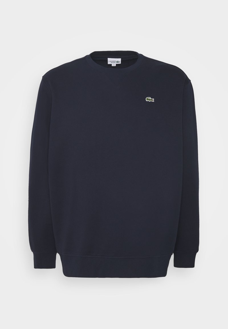 Sweat-shirt bleu marine à manches longues avec poignets et ourlet côtelés, arborant un petit logo crocodile vert Lacoste sur la poitrine gauche.