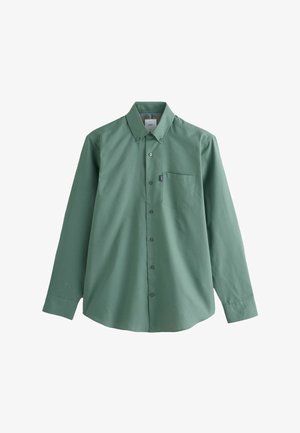 Pikkade varrukatega salvei-roheline nööbitav särk vasaku rinna tasku ja nööbitava kraega, valgel taustal.