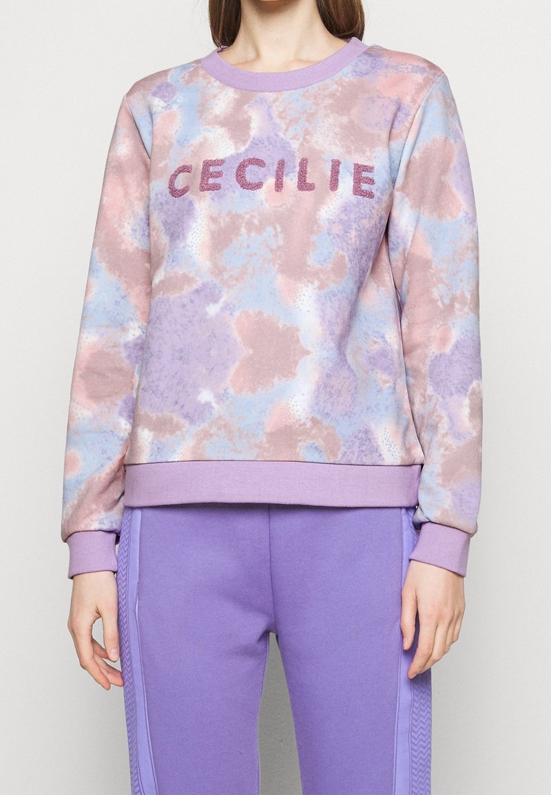 Felpa viola chiaro con un motivo tie-dye in rosa e blu. Presenta la scritta "CECILIE" in lettere texturizzate e luccicanti sul petto.