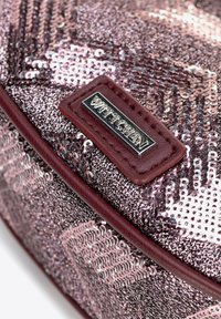 Roze pailletten tas met een textuur oppervlak, leren accenten en een zilveren logo plaat. Rondvorm met gladde randen.