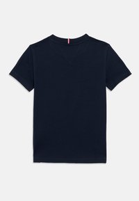 Σκούρο μπλε σκούρο μπλουζάκι με κοντά μανίκια από βαμβάκι. Διαθέτει στρογγυλή λαιμόκοψη και μια μικρή κόκκινη και λευκή λεπτομέρεια στο πίσω μέρος του λαιμού.