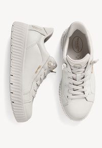 Sneaker grigie chiare con tomaia in pelle liscia, suola spessa e testurizzata, e cuciture dettagliate. Presentano lacci piatti e dettagli in oro.