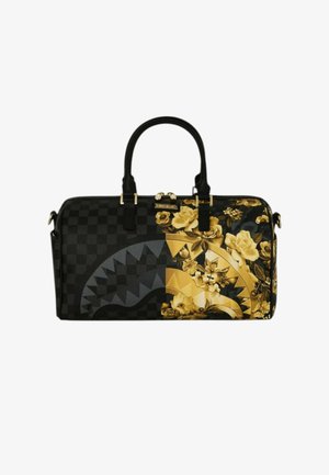 Sac polochon noir et or avec motif damier, design floral et graphique stylisé de bouche de requin, avec deux poignées noires et fermeture éclair dorée.