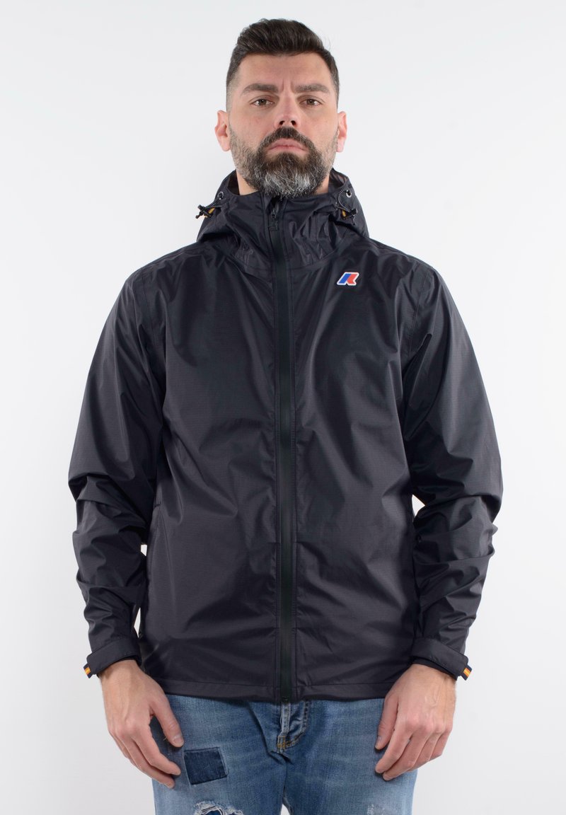 Black waterproof jacket with a zip front, adjustable hood, and logo on the left chest. Features elastic cuffs and a smooth texture.