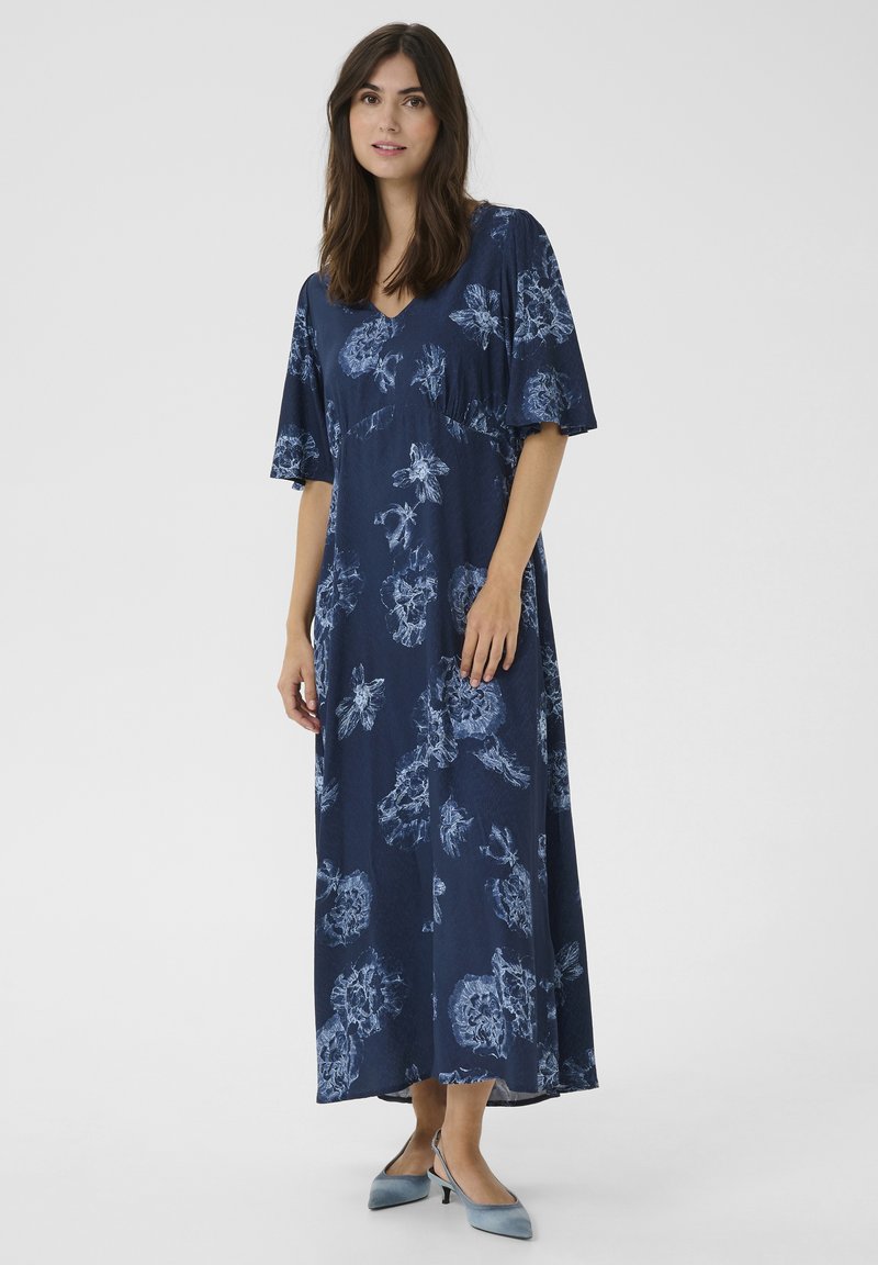 Tengerészkék virágmintás maxi ruha rövid ujjal, világoskék növényi mintákkal és V-kivágással. Simogatós anyag; laza fazon.