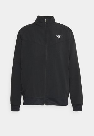Schwarze Zip-Up-Jacke mit hohem Kragen, hergestellt aus glattem Material und mit einem kleinen weißen Logo auf der linken Brustseite. Elastische Bündchen und Saum.