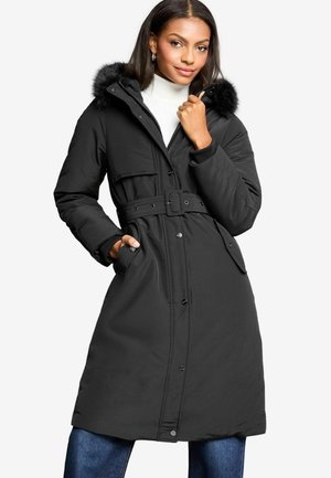 Zwarte geïsoleerde parka met een met bont gevoerde capuchon, een ceintuur in de taille, voorzakken en drukknoopsluitingen. Gemaakt van een textuurstof met een matte afwerking.