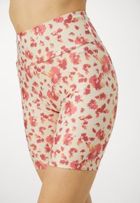 Shorts a vita alta con motivo floreale in crema, con accenti rosa e arancione. Realizzati in un tessuto leggero ed elastico per il massimo comfort.