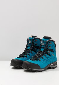 Türkise Wanderschuhe mit einer schwarzen Gummikappe, Metallösen und blauen sowie schwarzen Schnürsenkeln; verfügen über ein atmungsaktives Mesh-Futter.