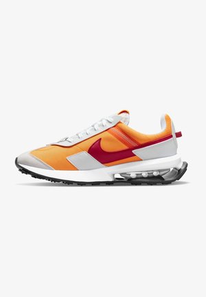 Zapatilla deportiva de corte bajo con parte superior de malla naranja, superposiciones blancas, logo Nike swoosh rojo, cámara de aire visible en la suela y suela exterior de caucho negro.