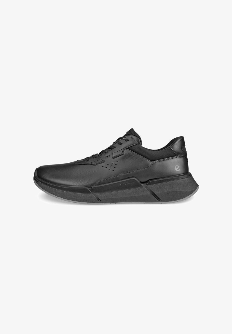 Czarne sportowe buty wykonane z materiału syntetycznego o gładkiej strukturze, z zaokrąglonym noskiem, sznurowanym fasonem i grubą, wyściółkowaną podeszwą.