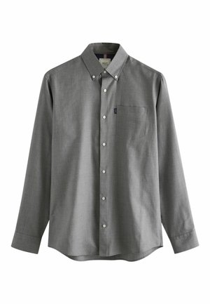 Cămașă gri cu mâneci lungi, din material texturat. Are o buzunar pe piept, o etichetă mică cu logo și nasturi albi.