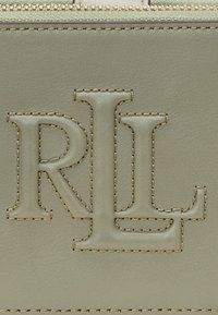 Zelená kožená peněženka s vyraženým logem "RL" a zlatým prošitím, s hladkým povrchem a zipovým uzavřením.