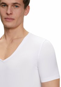 White short-sleeved V-neck T-shirt made of smooth fabric, featuring a fitted design with minimal seams.