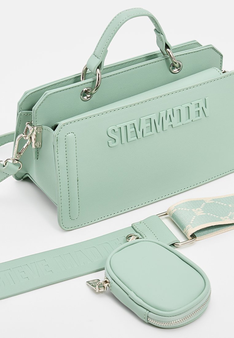 Mintgrön handväska med präglad "STEVE MADDEN"-logotyp, slät syntetmaterial, dubbla handtag, avtagbar rem och liten matchande påse.