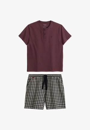 Bordowa koszulka henley z krótkim rękawem i detalem z guzikami, noszona z czarno-białymi szortami w kratkę z elastycznym paskiem i sznurkiem do regulacji.