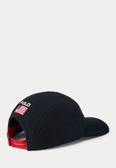 Schwarze Fleece-Kappe mit rotem verstellbarem Riemen. Auf der Vorderseite mit "POLO"-Logo und kleiner amerikanischer Flaggenstickerei. Glatte Textur und abgerundete Form.