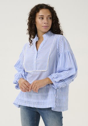 Blusa a righe blu e bianche con colletto alla cinese, maniche a palloncino e un elegante pizzo decorativo lungo la parte frontale. Tessuto leggero, vestibilità morbida.