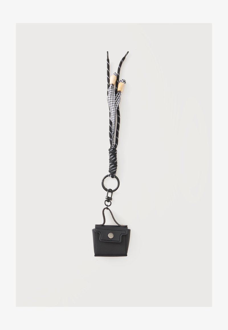 Mini pochette noire avec bouton-pression sur porte-clés boucle à motif noir et blanc avec perles en bois sur fond blanc uni.