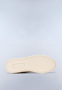 Suola di scarpa in gomma beige con scanalature testurizzate e branding. Bordo liscio e arrotondato con un design versatile adatto a vari stili di calzature.