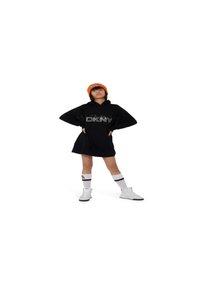 Robe noire à capuche avec le logo "DKNY" en sequins, associée à des baskets montantes blanches et des chaussettes jusqu'aux genoux avec une rayure noire, bonnet orange.