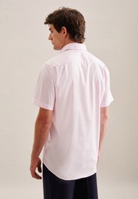 Camicia rosa chiaro a maniche corte con colletto, orlo dritto e fessure laterali, realizzata in tessuto morbido per una vestibilità comoda.