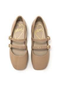 Zapatos Mary Jane de charol marrón con punta cuadrada, doble hebilla en las correas y suelas texturizadas con diseño de corazón dorado y logo.