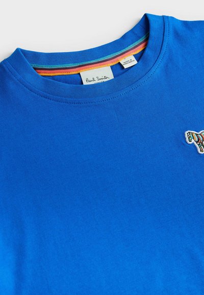 Blå bomulds T-shirt med rund halsudskæring. Broderet farverigt zebra-design på venstre bryst. Indersiden af kraven har regnbuefarver.