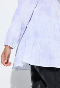 Lichtpaarse peplum top met lange mouwen, gemaakt van gestructureerde stof, met een geplooide zoom en een zachte, vloeiende pasvorm met elastische manchetten.