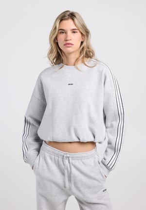 Light grey cropped sweatshirt with long sleeves, featuring black vertical stripes on the arms and a small logo on the front.