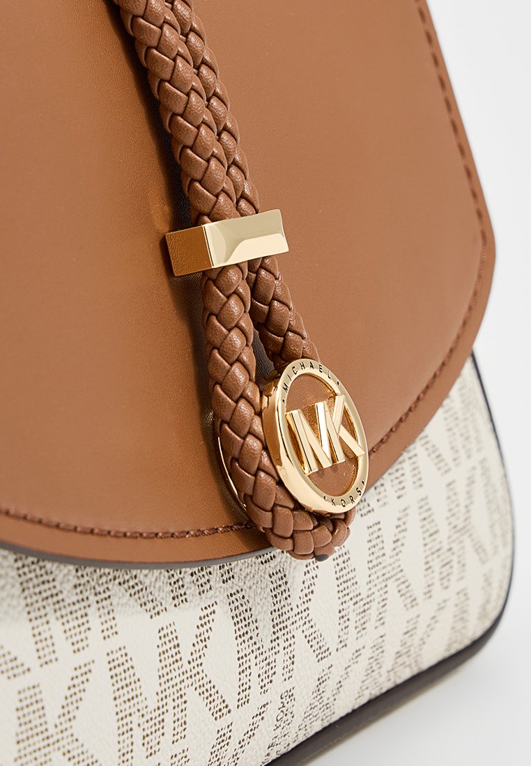 Sac à main en cuir tan avec une bandoulière tressée, matériel en logo doré, et un corps en tissu blanc à motifs arborant le nom de la marque.