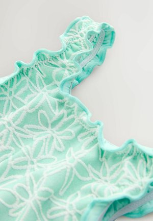 Licht turquoise badpak met witte bloemrijke borduurwerk en gerafelde randen. Gemaakt van rekbaar materiaal, met zachte texturen en een comfortabel ontwerp.