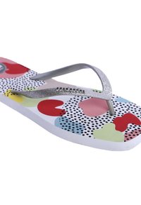 Chancla multicolor con suela de goma blanca con lunares negros, formas rojas y verdes, y una tira plateada brillante.