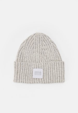 Lichtgrijze gebreide beanie met ribbelstructuur en een omgeslagen rand. Voorzien van een vierkante UGG-logo patch aan de voorkant.