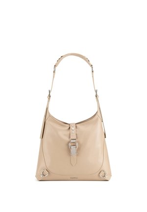 Beige leren schoudertas met verstelbare riem, metalen gesp aan de voorkant en zilverkleurige metalen ringdetails op een witte achtergrond.