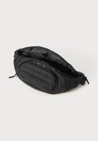 Schwarze Nylon-Tasche mit Reißverschlusshauptfach, einer Vordertasche mit gestepptem Design und verstellbaren Trägern.