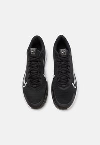 Scarpe sportive nere con tomaia in mesh testurizzato, lacci piatti, dettagli bianchi sui lati e suola ammortizzata, con logo sulla linguetta.