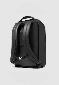 Zwarte leren rugzak met een gestructureerde vorm, duurzame ritsen, gevoerde schouderbanden en een bovenhandgreep om te dragen.