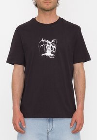 Svart bomull t-shirt med ett centralt vitt motiv av ett träd. Kortsleeves, rund hals och avslappnad passform.