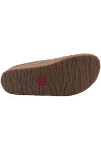 Brown rubber outsole with a textured pattern, featuring a red circular logo and a raised edge, designed for grip and durability.