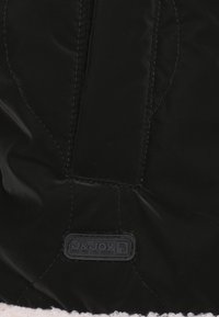 Zwarte gewatteerde stof met een glanzende afwerking, voorzien van een gestikt patroon. Inclusief een J&JOY logo-label en een contrasterende beige fluffy voering.
