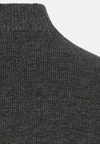 Schiefergrauer Rollkragenpullover mit geripptem Muster und taillierter Passform. Der Strickstoff ist weich und leicht elastisch.