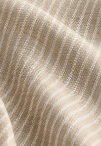 Tessuto in tessuto color cammello con strisce bianche, caratterizzato da una trama intrecciata e un delicato motivo a onde. Finitura liscia, materiale leggero.