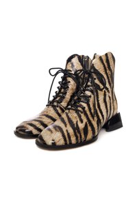 Enkele boots met dierenprint met een beige en zwart gestreept patroon, een zachte haarachtige textuur, vetersluiting aan de voorkant en een chunky zwarte hak.