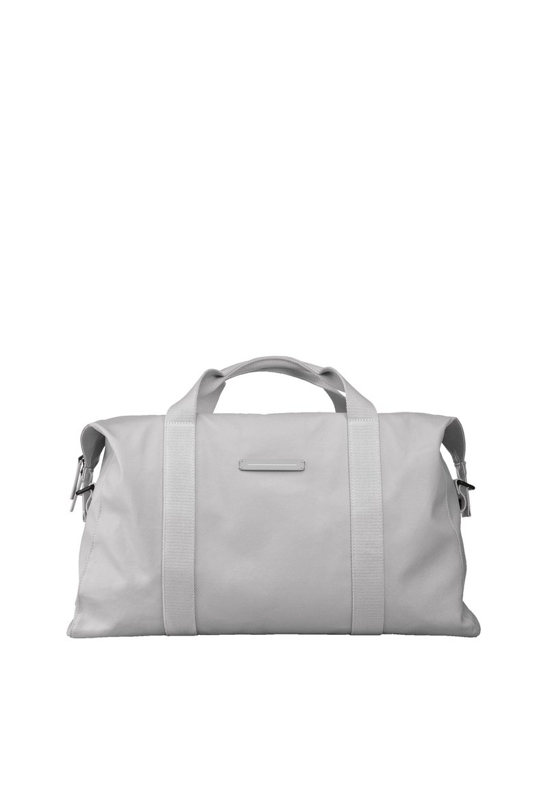 Sac de sport en tissu gris avec des poignées robustes et une bandoulière réglable. Il possède une poche frontale plate et un design lisse et minimaliste.